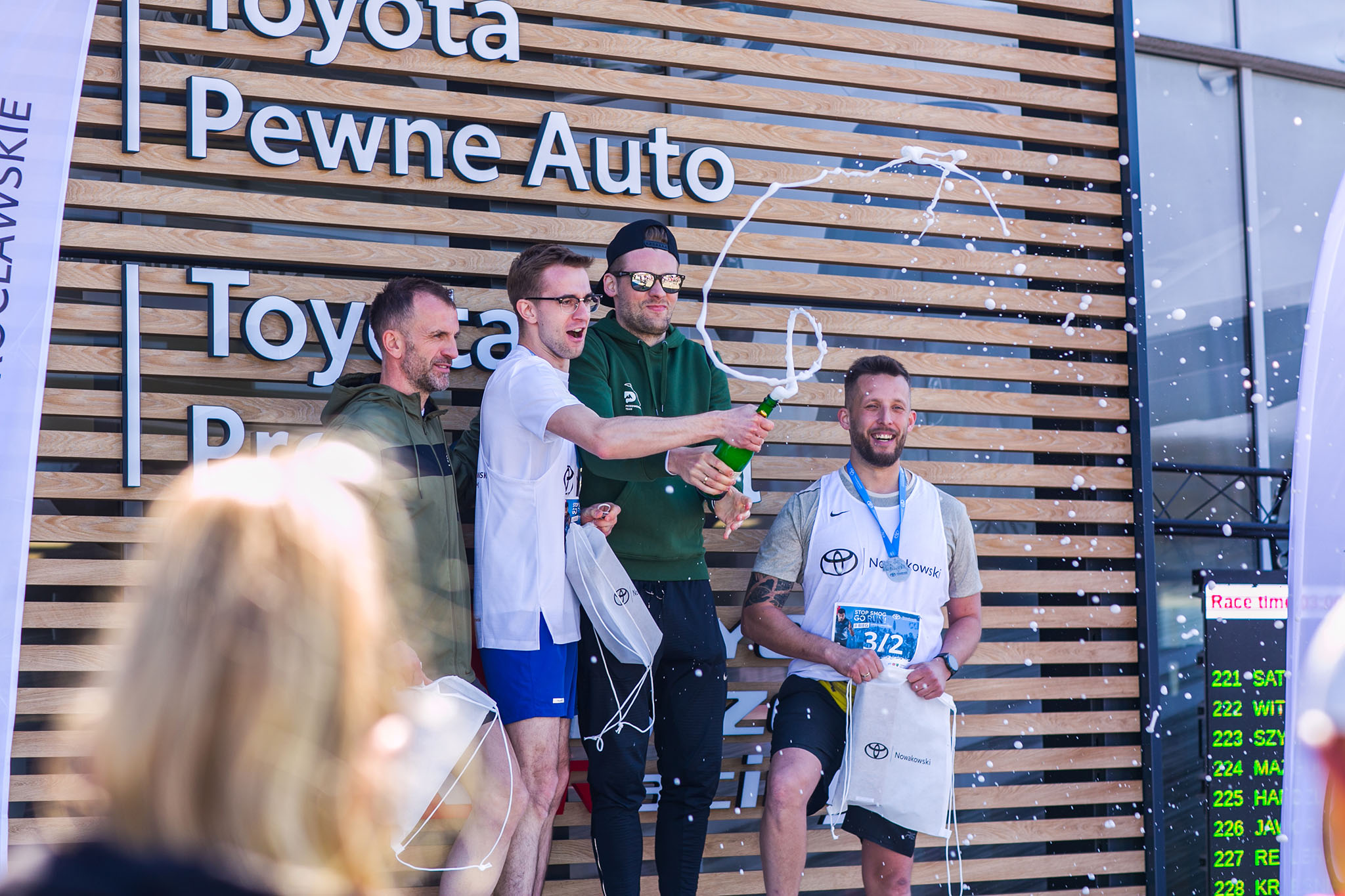 Radość zwycięzców na podium biegu Toyota Nowakowski – profesjonalny reportaż eventowy potwierdzający najwyższą jakość obrazu.